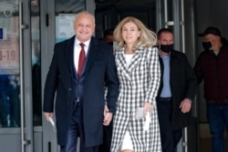 Incumbent Moldovan President Igor Dodon and his wife Galina smile while walking out of a voting station during the country's presidential election runoff in Chisinau, Moldova, Nov. 15, 2020.