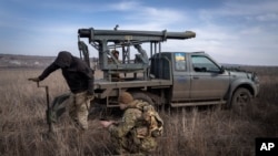 Soldados ucranianos de la 56.a Brigada de Infantería Motorizada Mariupol se preparan para disparar un sistema de lanzamiento múltiple de cohetes hacia posiciones rusas en la línea del frente, cerca de Bakhmut, región de Donetsk, Ucrania, el martes 5 de marzo de 2024.