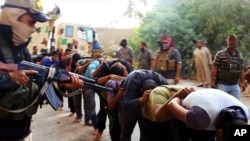 This image appears to show militants from the Islamic State of Iraq and the Levant (ISIL) leading captured Iraqi soldiers after taking over a base near Tikrit, Iraq. The photo was posted on a militant website June 14, 2014. 