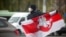 Участник протестной акции в Минске с историческим национальным флагом Беларуси в руках (архивное фото) 