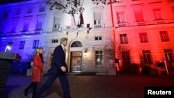 U.S. Secretary of State John Kerry (C), next to U.S. ambassador to France Jane D. Hartley, leaves after delivering a speech at the U.S. embassy in Paris illuminated with the colors of the French national flag, Nov. 16, 2015.