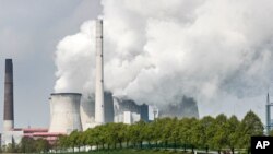 A coal-fired RWE power plant steams on a sunny day in Neurath, Germany, April 29, 2021, as Germany's top court ruled that the country's government has to set clear goals for reducing greenhouse gas emissions after 2030.