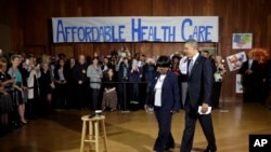 President Barack Obama walks in with volunteer Edna Pemberton before speaking with other volunteers who helped people enroll through the HealthCare.gov site at Temple Emanu-El, Nov. 6, 2013