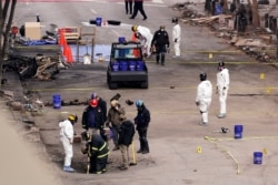 FBI and ATF personnel examine the area involved in a Christmas Day explosion Tuesday, Dec. 29, 2020, in Nashville, Tenn.