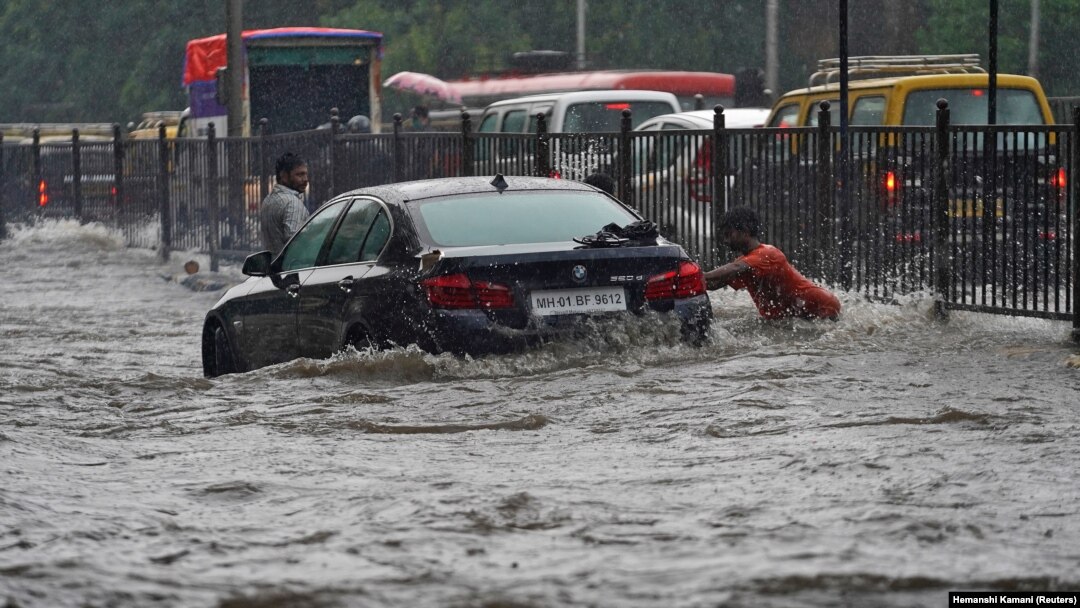 Seorang pria mendorong mobil, terjebak di jalan yang banjir, saat hujan lebat di Mumbai, India, 4 Juli 2020. (Foto: REUTERS/Hemanshi Kamani)