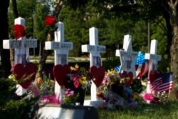 FILE - An American flag is placed next to markers representing the people killed in a newsroom shooting, at a makeshift memorial at the scene outside the office building housing The Capital Gazette newspaper in Annapolis, Md., on July 1, 2018.