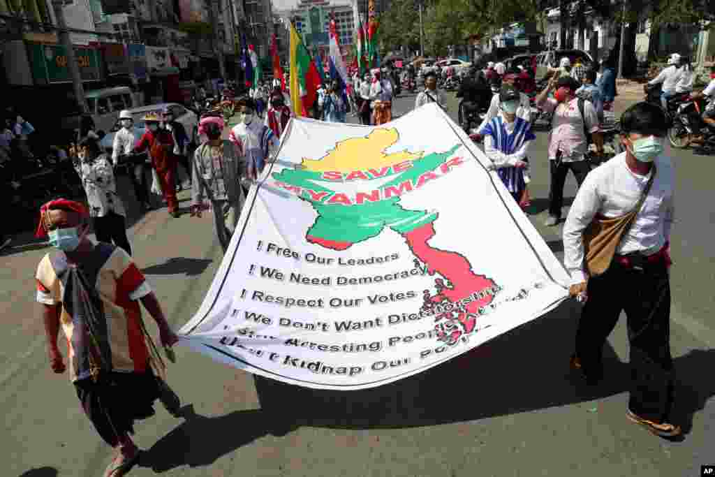 Anti-coup protesters hold a banner which reads: &quot;Save Myanmar&quot; as they march in Mandalay, Feb. 22, 2021.