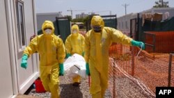 FILE - Members of medical team carry the body of a deceased COVID patient on a stretcher at a Ministry of Health Infectious Disease Unit in Juba, South Sudan, May 28, 2020. 