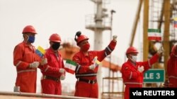 Trabajadores de la compañía estatal Pdvsa ondean banderas iraníes y venezolanas mientras atraca el petrolero Fortune, en la refinería El Palito, en Puerto Caballero, Venezuela. Mayo 25, 2020.
