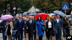 Belgrade-backed Srpska Lista leader Goran Rakic, center left, with supporters arrives at a polling station in northern Serb-dominated part of ethnically divided town of Mitrovica, Kosovo, Oct. 6, 2019.