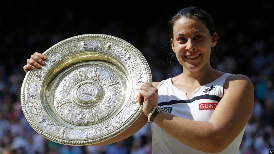 Marion Bartoli dari Perancis dengan trofi Wimbledon (6/7). (AP/Anja Niedringhaus)