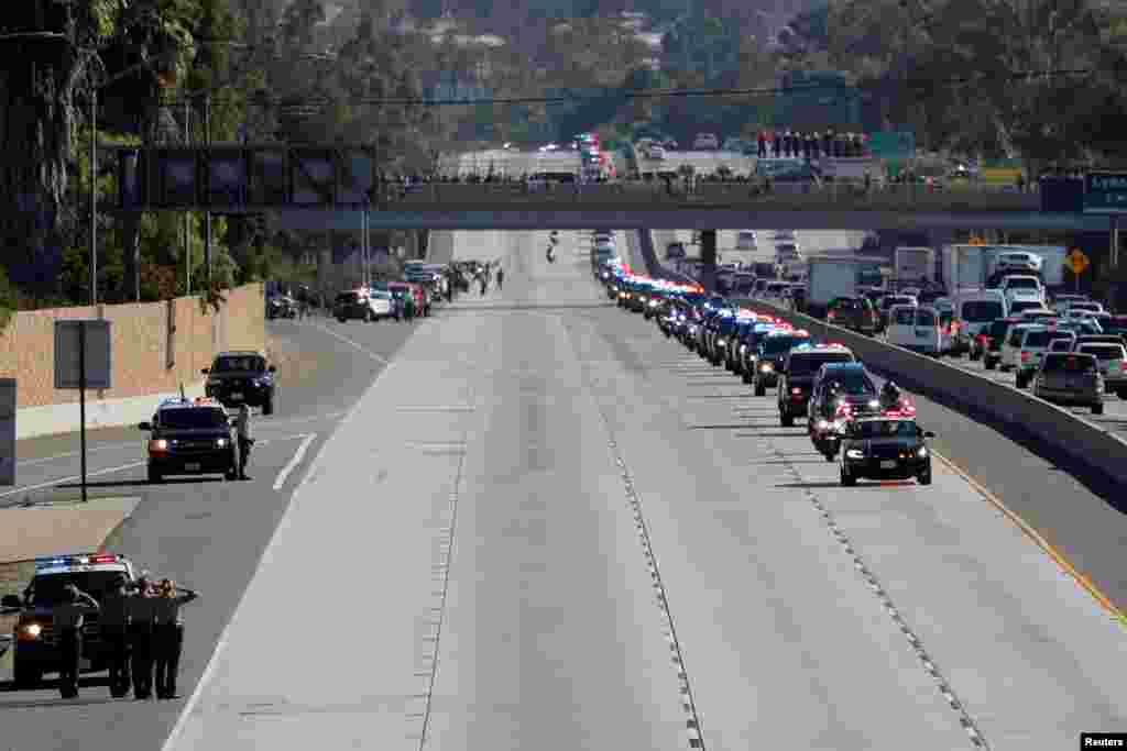 A procession for the body of Sheriff Sgt. Ron Helus, who was killed in a mass shooting at a Southern California bar, drives along Ventura Highway 101 in Thousand Oaks, California. Twelve people were killed by a gunman late Wednesday. Helus was immediately hit with numerous gunshots after going inside to confront the shooter, and he died after being taken to a hospital.