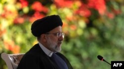 FILE - Iranian President Ebrahim Raisi speaks with Ugandan President at the State House in Entebbe on July 12, 2023, during a state visit to Uganda. 