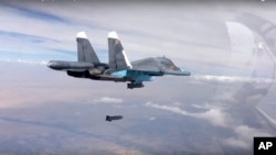 A Russian Su-34 strike fighter releases a bomb in Syria in this photo made from footage on the Russian Defense Ministry's official website, Oct. 9, 2015.