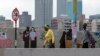 Des gens marchent dans une rue du centre-ville de Johannesburg, en Afrique du Sud, le lundi 16 mars 2020. (AP Photo/Themba H.)