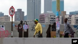 Des gens marchent dans une rue du centre-ville de Johannesburg, en Afrique du Sud, le lundi 16 mars 2020. (AP Photo/Themba H.)