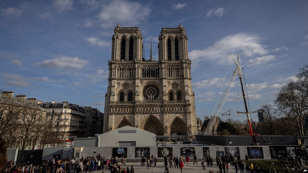 FILE - Scaffolding is being removed around the spire of Notre Dame de Paris cathedral, showing the rooster and the cross, in Paris, Feb. 17, 2024. 