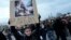 Một người phụ nữ cầm biểu ngữ với ảnh Tổng thống Pháp Emmanuel Macron đang ngồi trên thùng rác và dòng chữ "vua rác" trong một cuộc biểu tình ở Paris vào ngày 17/3/2023 để phản đối quyết định tăng tuổi nghỉ hưu từ 62 đến 64 của ông Emmanuel Macron.