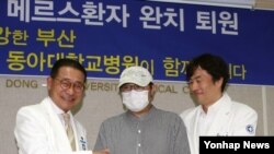 부산의 두 번째 중동호흡기증후군(메르스) 확진자이자 143번 환자인 이모(31·가운데)씨가 25일 완치판정을 받고 퇴원하며 김상범 병원장(왼쪽)과 주치의 이혁 교수의 격려를 받고 있다.