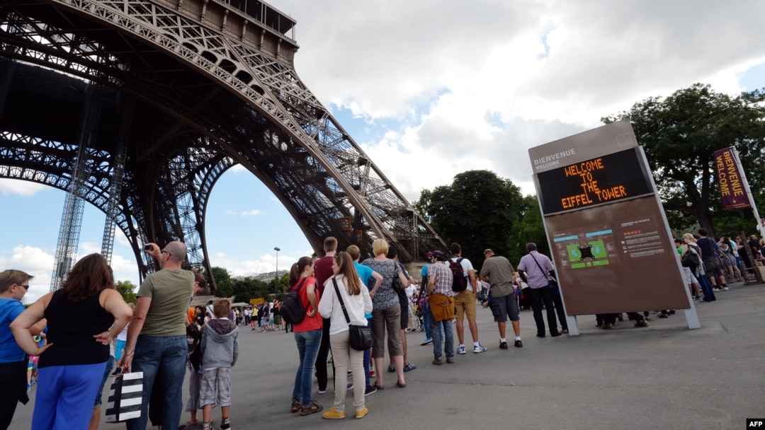 People queue to visit the Eiffel tower, Aug. 9, 2013 in Paris, after the monument reopened its door following its evacuation over a bomb alert.