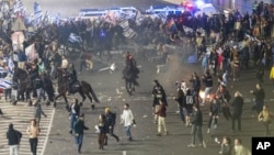 Israeli police disperse demonstrators blocking a highway during a protest against plans by Prime Minister Benjamin Netanyahu's government to overhaul the judicial system in Tel Aviv, Israel, Monday, March 27, 2023. (AP Photo/Oren Ziv)