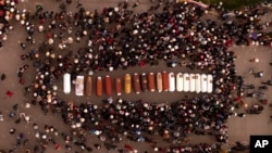 Residents gather round the coffins containing the remains of people who died during protests demanding the resignation of Peruvian President Dina Boluarte, in Juliaca, Peru, Jan. 10, 2023.