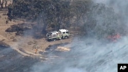 In this image made from video, an aerial scene shows firefighters extinguishing wildfires in the Adelaide Hills, Australia, Dec. 24, 2019.