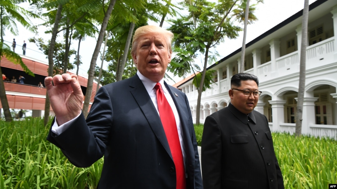 美国总统川普在新加坡与朝鲜领导人金正恩一同行走，并回答媒体问题（2018年6月12日）。