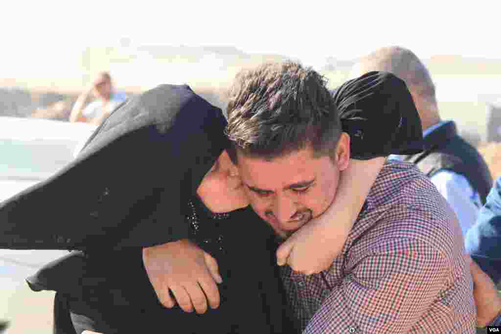 A mother weeps and hugs her son, who she hadn't seen in the two and a half years while he was trapped at the Khazir camp in Kurdish Iraq. (H. Murdock/VOA)