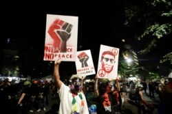 Demonstrators hold signs during a Black Lives Matter protest at the Mark O. Hatfield United States Courthouse, July 27, 2020, in Portland, Oregon.