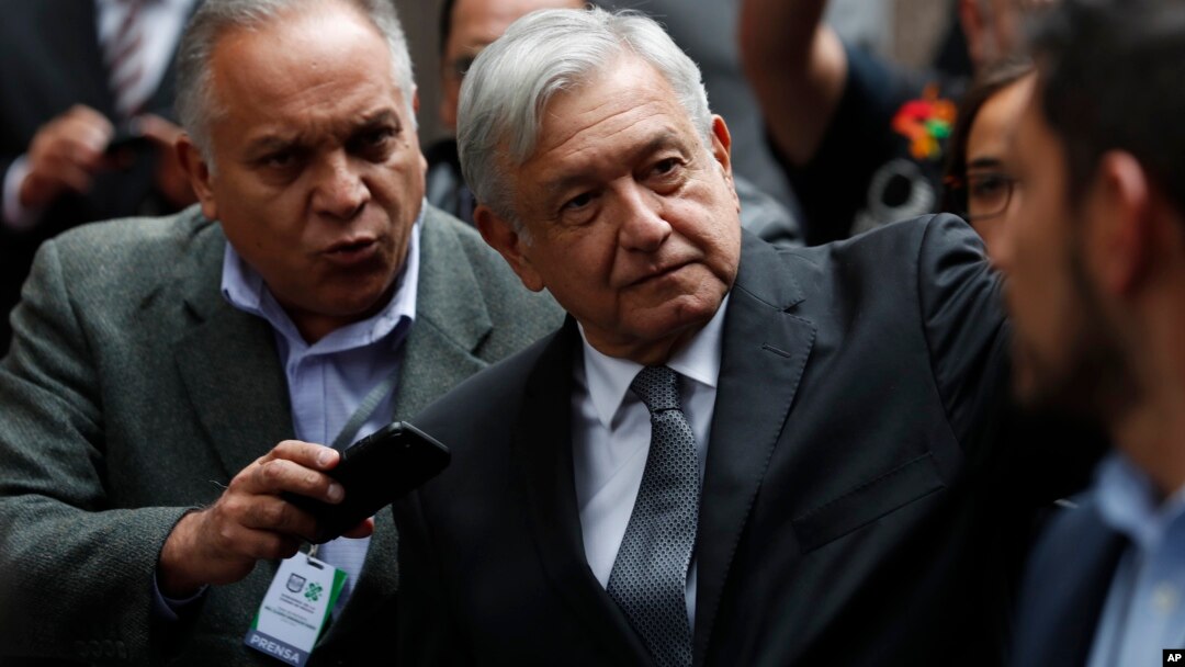 Mexico's President Andres Manuel Lopez Obrador waves as he arrives for the swearing-in ceremony for Mayor-elect Claudia Sheinbaum, in Mexico City, Dec. 5, 2018. 