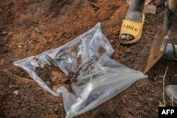 FILE - A human skull can be seen in a mass grave with victims of the 1994 Rwandan Genocide found under the foundations of a house in Ngomaon January 23, 2023, where more than 82 bodies have been found since January 21, 2024