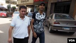 Once physically female, Mohammad Alaam (L) and his friend stroll through a Cairo suburb, June 13, 2016. (H. Elrasam/VOA)