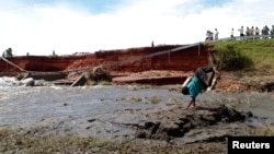 Un enfant joue près d'un pont endonnagé à cause des inondations, à Kampala, le 8 mai 2013. (Photo d'illustration)