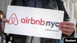 Supporters of Airbnb stand during a rally before a hearing called "Short Term Rentals: Stimulating the Economy or Destabilizing Neighborhoods?" at City Hall in New York, Jan. 20, 2015. 