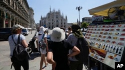 Turistas tratan de protegerse del calor frente al Duomo en Milán, Italia, el 16 de julio del 2024.