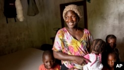 Coach Isabelle Sambou, 43 years old, two-time Olympian and nine-time African wrestling champion, plays with children in her house in Mlomp, southern Senegal, on July 10, 2024.