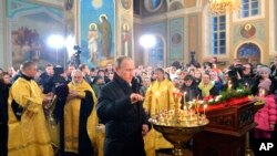Presiden Rusia Vladimir Putin (tengah) menghadiri misa Natal Ortodoks di desa Turginovo, 150 kilometer, Rusia (6/1).