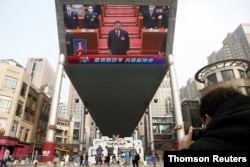 Giant screen shows Chinese President Xi Jinping attending the closing session of the National People's Congress (NPC) at the Great Hall of the People, in Beijing.