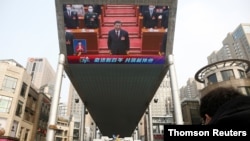 巨型屏幕显示中国国家主席习近平在北京人民大会堂出席全国人大闭幕会。