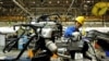 An employee works on an automobile assembly line at a factory in Qingdao, Shandong province, China, March 1, 2016. Activity in China's manufacturing sector shrank more sharply than expected in February.