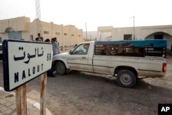 FILE - A van crosses the Tunisian-Libyan border of Dhuheiba, Tunisia, April 21, 2011.
