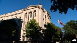 La bandera estadounidense ondea frente a la sede del Departamento de Justicia en Washington.