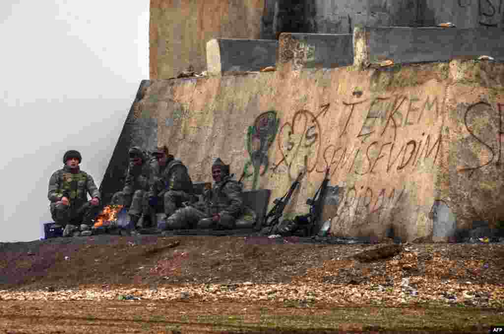 Turkish soldiers gather around a bonfire in Mursitpinar in the Sanliurfa province near the border with Syria.