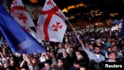 Orang-orang mengibarkan bendera Georgia dan Eropa selama perayaan penandatanganan perjanjian dengan Uni Eropa di Tbilisi, 27 Juni 2014. (Foto: Reuters/David Mdzinarishvili)