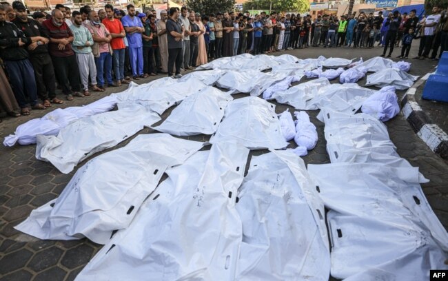 Los palestinos se reúnen mientras lloran por los cuerpos de los muertos en el bombardeo israelí en Deir Balah, en el centro de la Franja de Gaza, en el hospital Shuhada Al-Aqsa de la misma ciudad el 6 de noviembre de 2023. ​