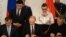 Russia's President Vladimir Putin (C),  Crimean parliament speaker Vladimir Konstantionov (L)  and Alexei Chaly, Sevastopol's new de facto mayor (R), sign a treaty to make Crimea part of Russia in the Kremlin in Moscow on March 18, 2014. 