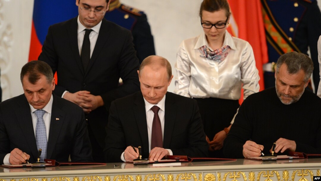Tổng thống Nga Vladimir Putin, Chủ tịch Quốc hội Crimea Vladimir Konstantionov (trái) và thị trưởng Sevastopol Alexei Chaly ký hiệp ước sáp nhập Crimea vào Nga, ngày 18/3/2014.