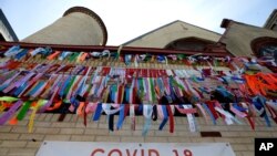 FILE - Ribbons hang in remembrance of victims of the coronavirus pandemic outside the Grant African Methodist Episcopal Church, May 19, 2020, in Boston.
