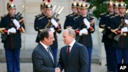 Presiden PerancisFrancois Hollande (kiri) menyambut Presiden Rusia Vladimir Putin saat tiba di Istana Elysee Palace, Paris (5/6). (AP/Francois Mori)